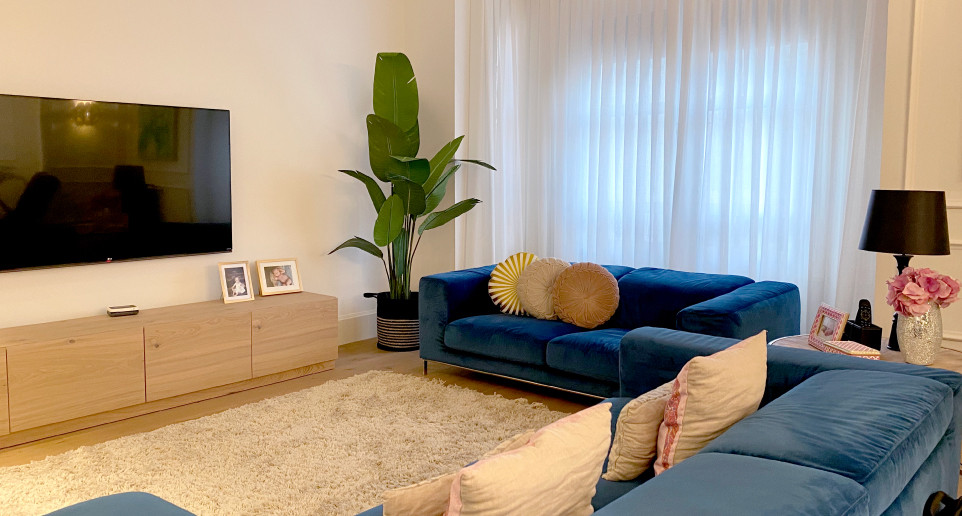 Réalisation d'un grand salon design ouvert avec un mur blanc, un sol en bois brun, un téléviseur fixé au mur et un sol marron.