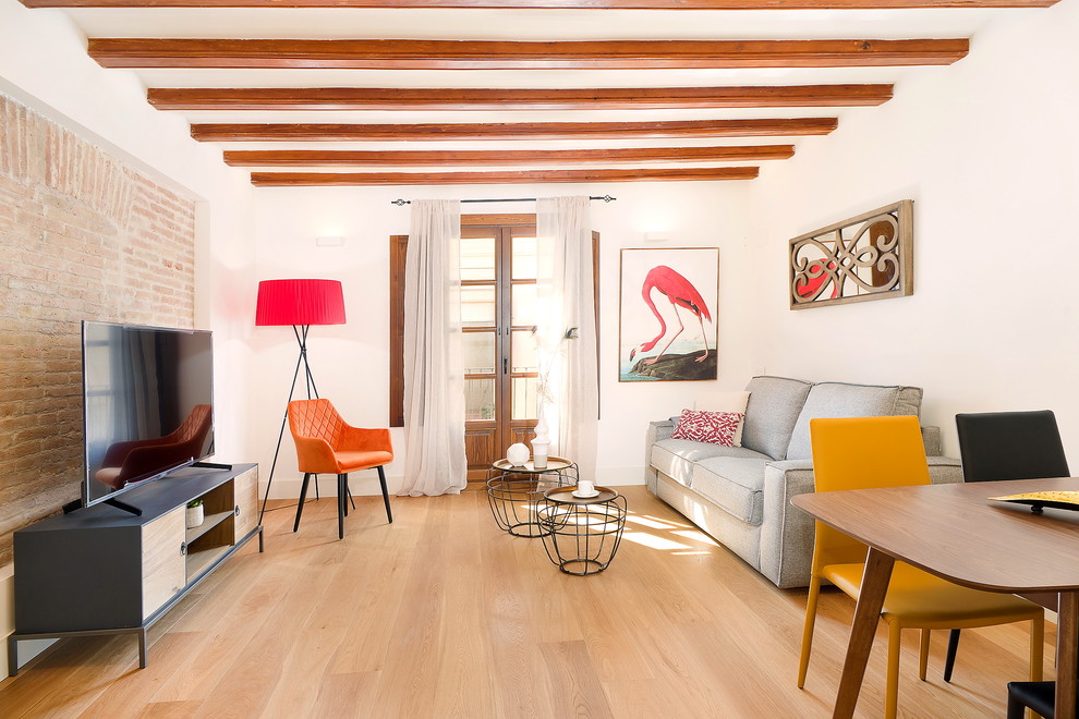 Diseño de salón abierto contemporáneo de tamaño medio con paredes blancas, suelo de madera en tonos medios, televisor independiente y suelo marrón
