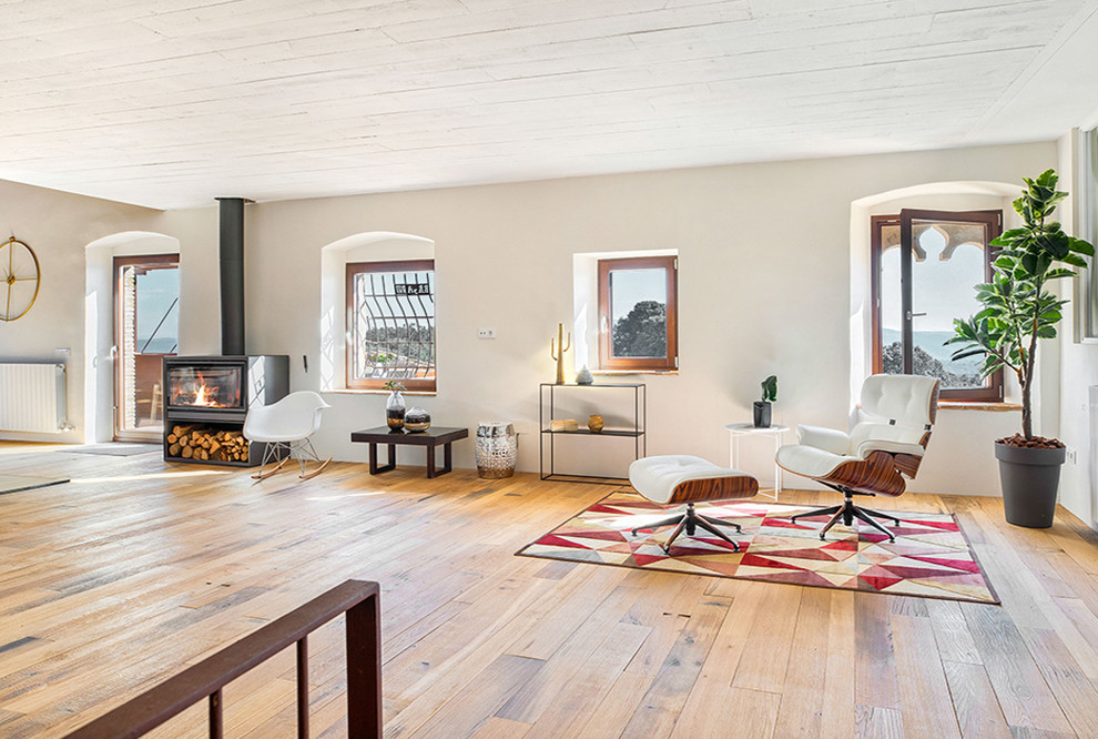 Diseño de salón abierto rural extra grande con suelo de madera en tonos medios y estufa de leña