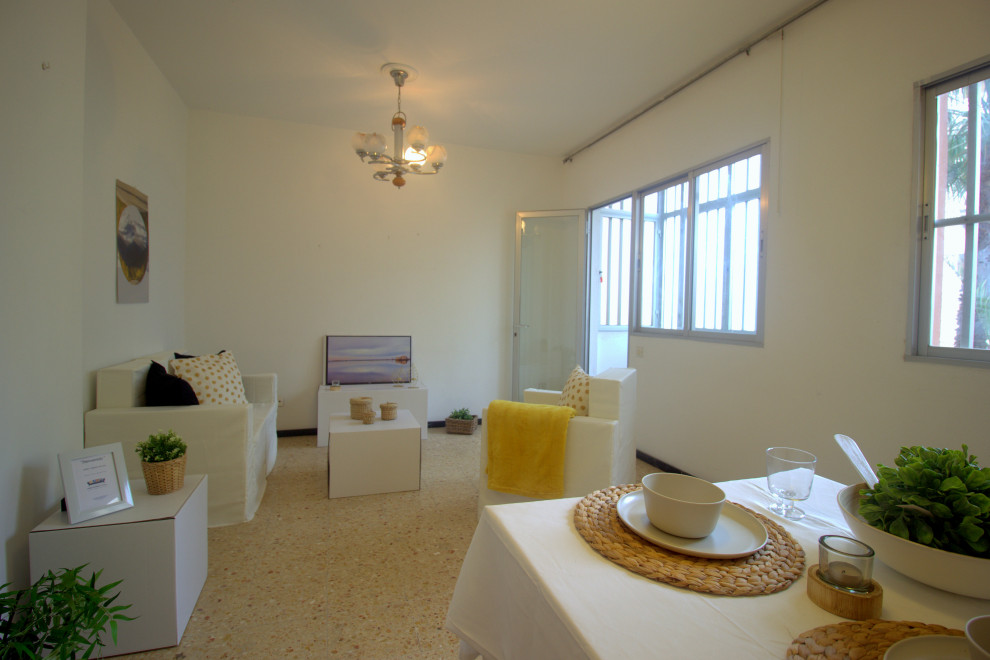 Minimalistisk inredning av ett litet separat vardagsrum, med vita väggar, klinkergolv i keramik och orange golv