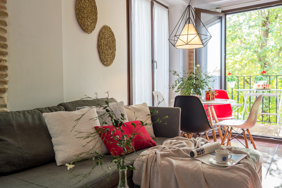 Свежая идея для дизайна: маленькая открытая гостиная комната в стиле неоклассика (современная классика) с белыми стенами, полом из терракотовой плитки, отдельно стоящим телевизором и коричневым полом для на участке и в саду - отличное фото интерьера