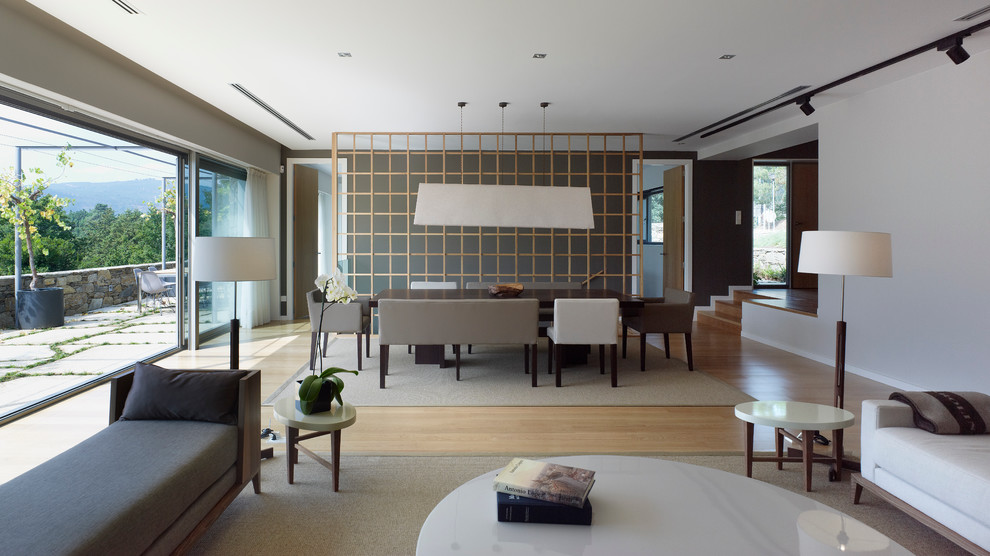 Imagen de salón para visitas abierto contemporáneo grande sin chimenea y televisor con paredes blancas y suelo de madera en tonos medios