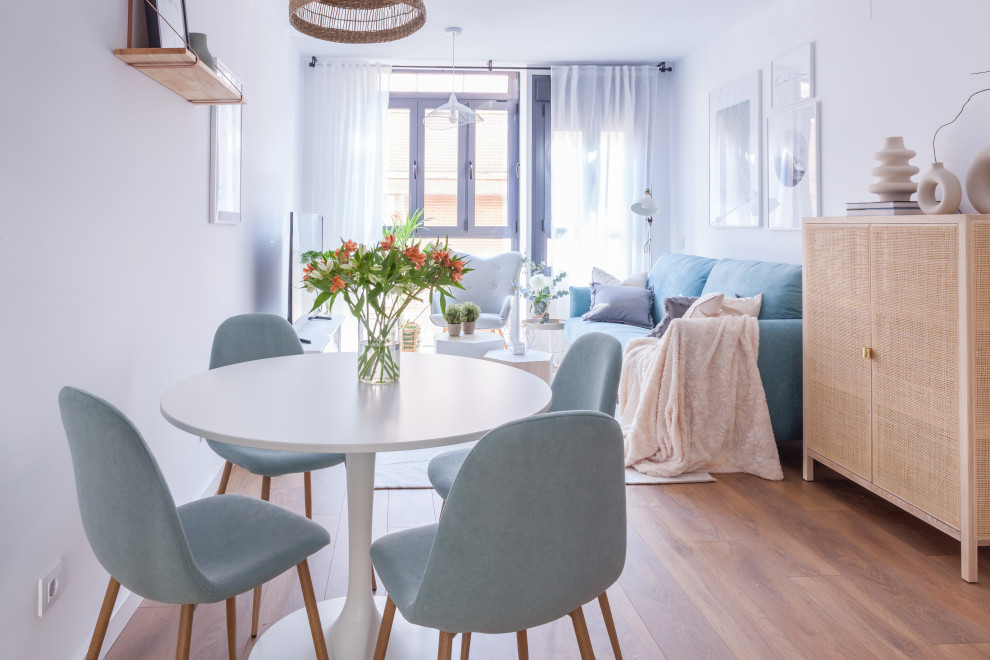 Diseño de salón abierto nórdico pequeño con paredes blancas, suelo de madera en tonos medios, televisor colgado en la pared y suelo marrón