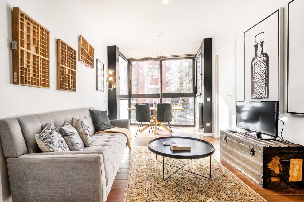 Ispirazione per un soggiorno contemporaneo con sala formale, pareti bianche, pavimento in legno massello medio, TV autoportante e pavimento marrone