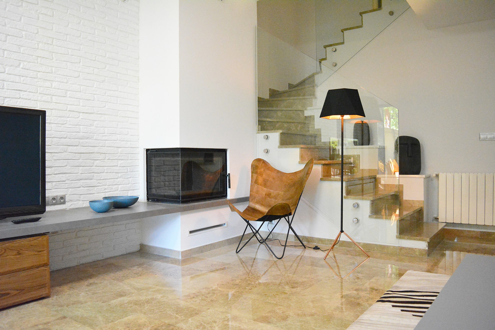 Idee per un soggiorno minimal di medie dimensioni con pavimento in marmo, camino bifacciale e cornice del camino in intonaco