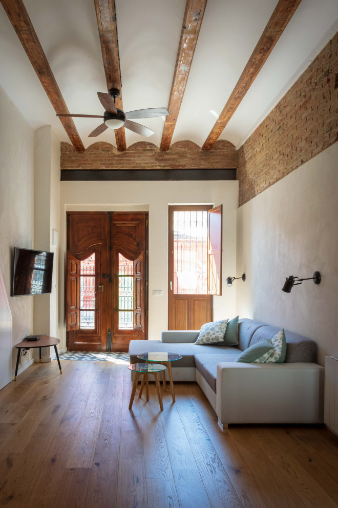 Bild på ett mellanstort medelhavsstil allrum med öppen planlösning, med vita väggar, mellanmörkt trägolv och brunt golv
