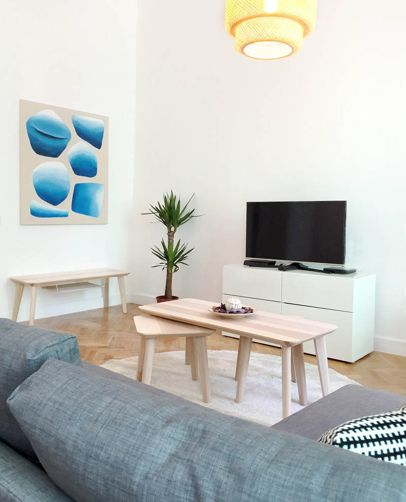 Immagine di un piccolo soggiorno design aperto con pareti bianche e pavimento in legno massello medio