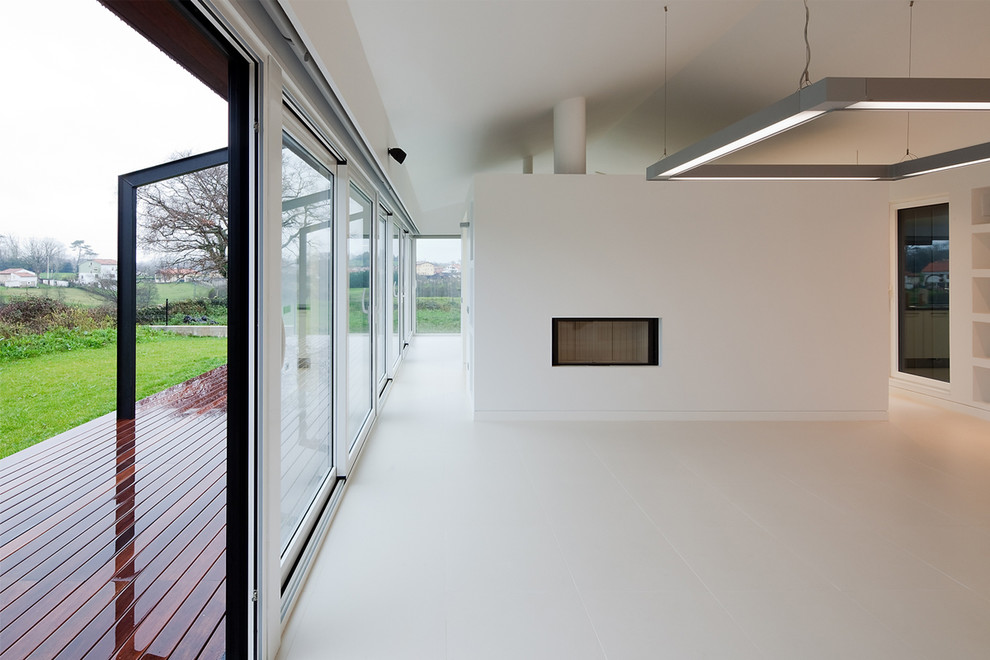 Großes Modernes Wohnzimmer mit weißer Wandfarbe, Porzellan-Bodenfliesen, Kaminumrandung aus Metall, Multimediawand und Tunnelkamin in Sonstige