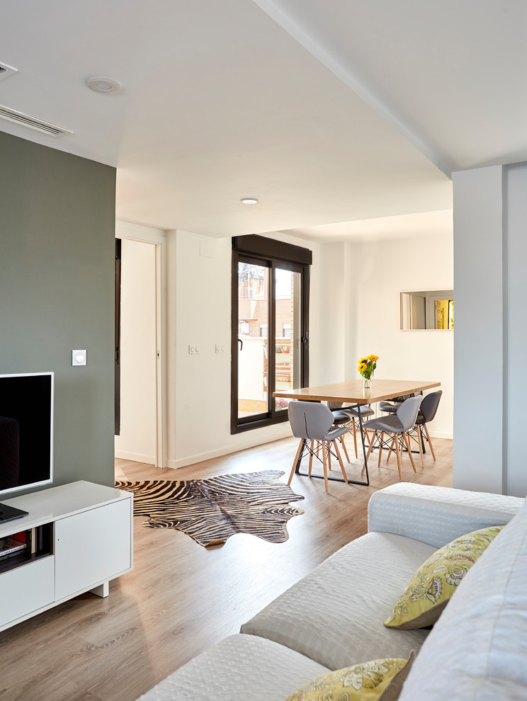 Foto de salón para visitas abierto moderno de tamaño medio con paredes verdes, suelo de madera en tonos medios y pared multimedia