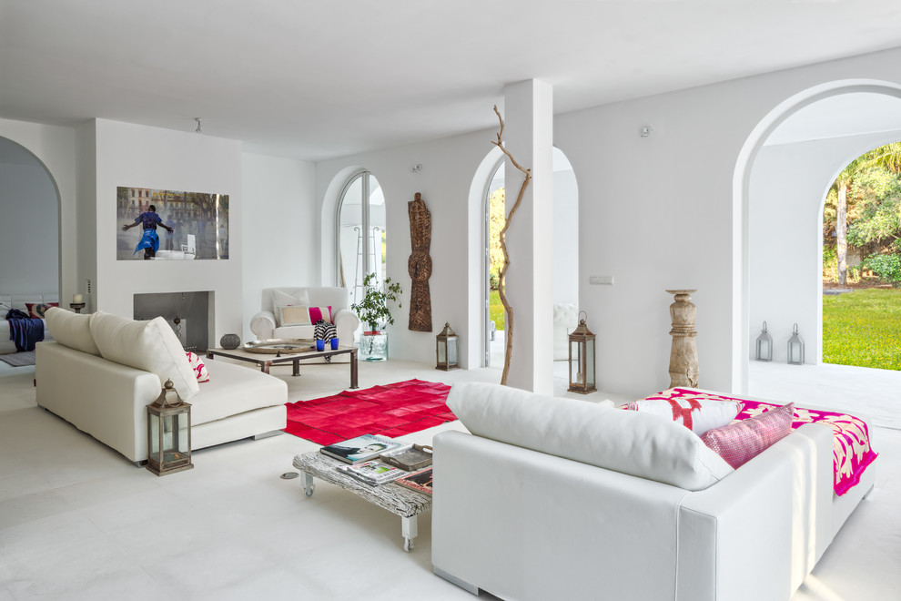 Großes, Repräsentatives, Fernseherloses, Offenes Mediterranes Wohnzimmer mit weißer Wandfarbe, Kamin, verputzter Kaminumrandung und Keramikboden in Malaga