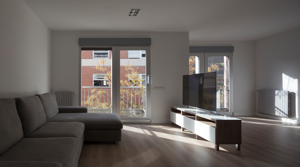Design ideas for a large scandinavian open plan living room with white walls, light hardwood flooring, a freestanding tv and beige floors.