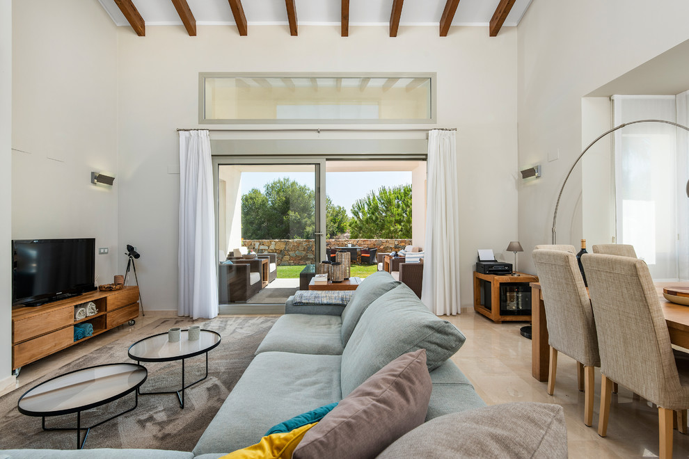 Modelo de salón abierto mediterráneo con paredes blancas, televisor independiente y suelo beige