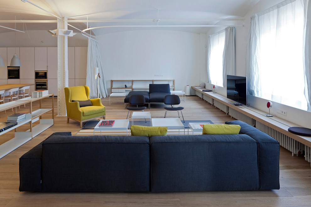 Esempio di un grande soggiorno design aperto con sala formale, pareti bianche, pavimento in legno massello medio, nessun camino e TV autoportante