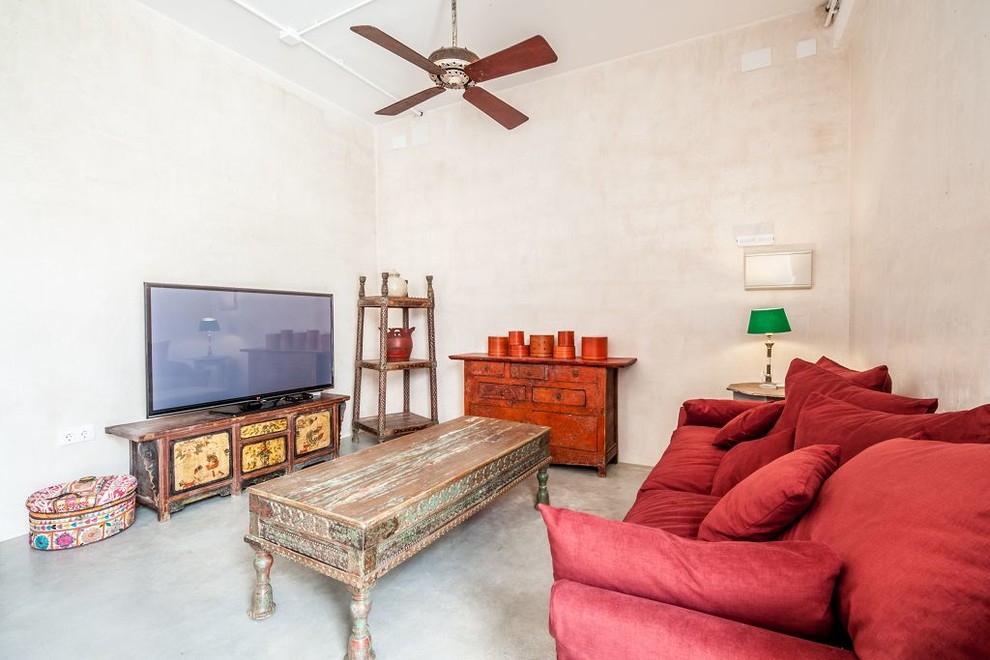 Foto di un soggiorno mediterraneo di medie dimensioni con pareti beige, pavimento in cemento, TV autoportante e pavimento grigio