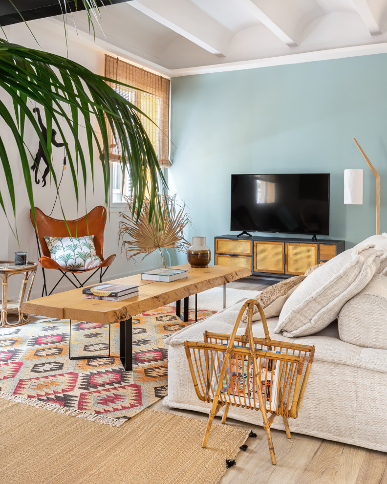 Esempio di un soggiorno tropicale con pareti blu, parquet chiaro, TV autoportante, pavimento beige e soffitto a volta