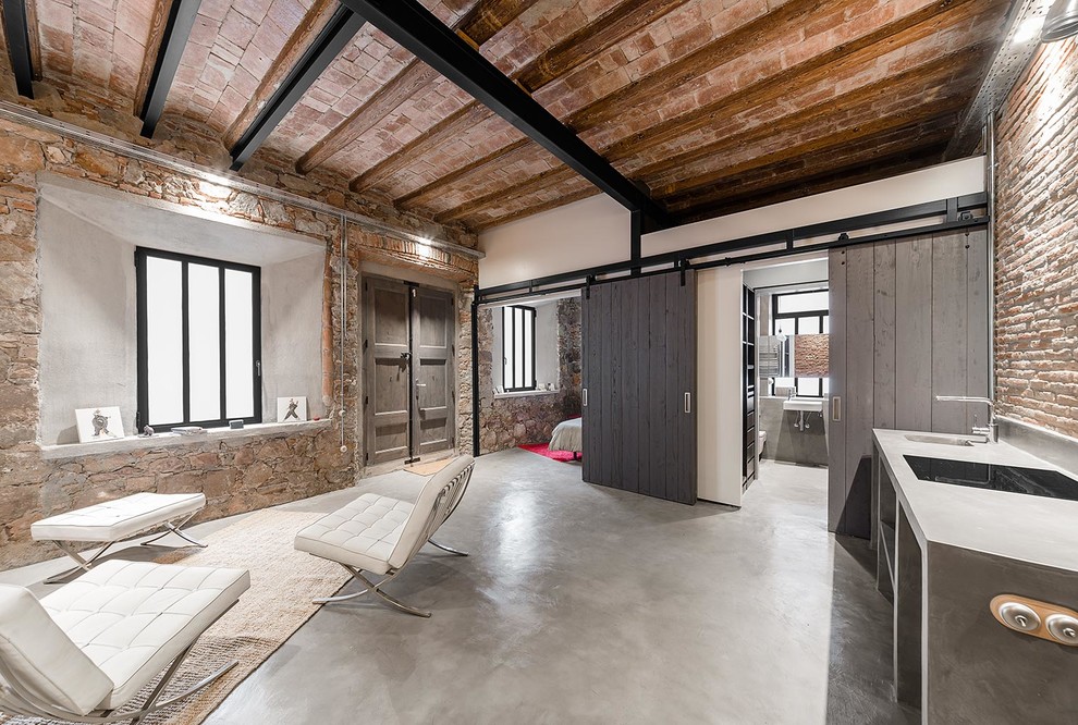 Foto de salón abierto industrial de tamaño medio sin chimenea y televisor con paredes blancas y suelo de cemento