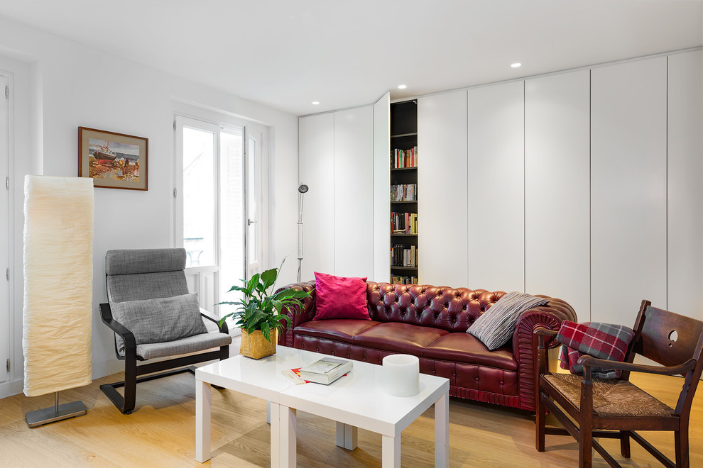 Example of a mid-sized trendy light wood floor living room design in Madrid with white walls