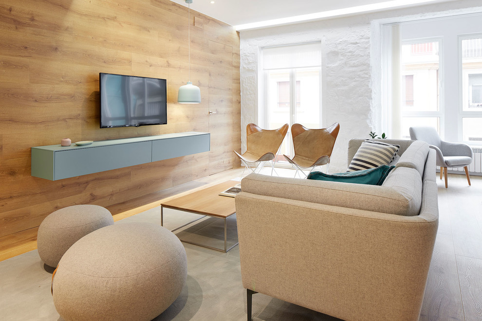 Ejemplo de salón abierto nórdico con paredes blancas y televisor colgado en la pared