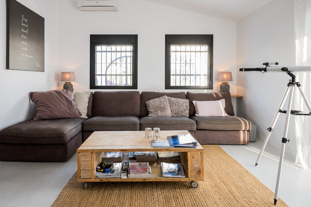 Пример оригинального дизайна: парадная, изолированная гостиная комната среднего размера в стиле неоклассика (современная классика) с белыми стенами, бетонным полом и коричневым диваном без камина, телевизора