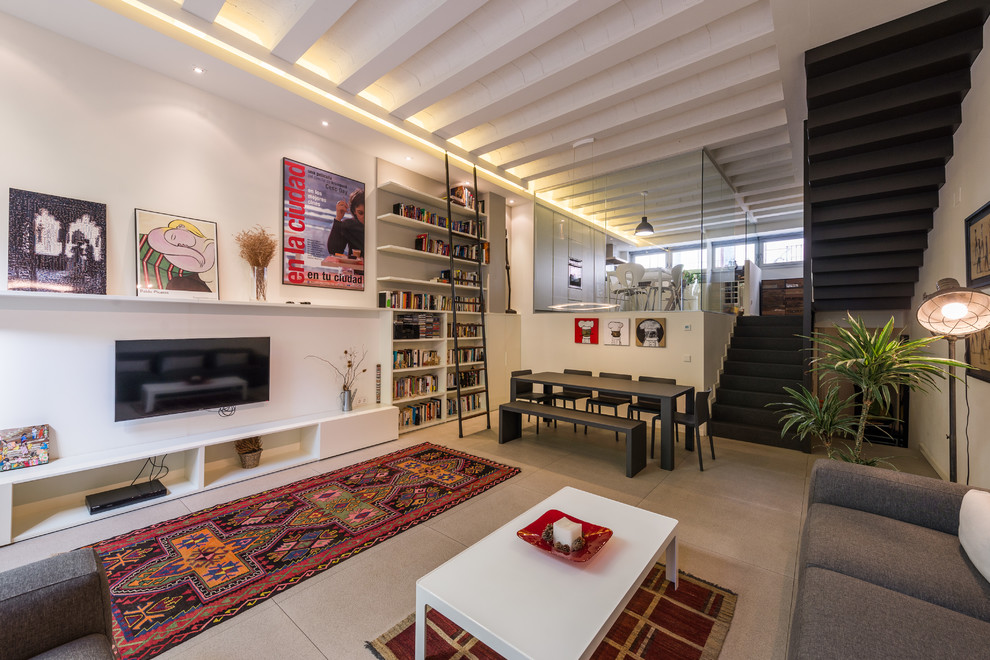 Esempio di un grande soggiorno minimal aperto con libreria, pareti bianche, nessun camino e TV a parete