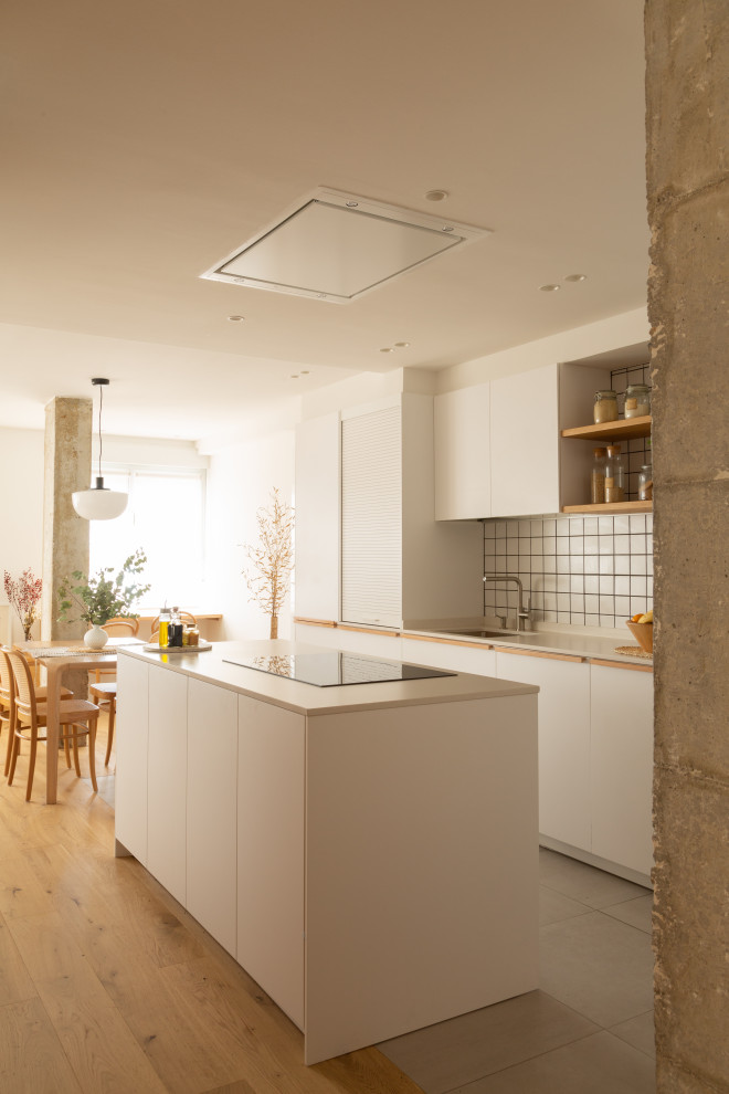 This is an example of a large scandinavian galley kitchen/diner in Other with a submerged sink, flat-panel cabinets, white cabinets, white splashback, porcelain splashback, integrated appliances, porcelain flooring, an island, grey floors and white worktops.
