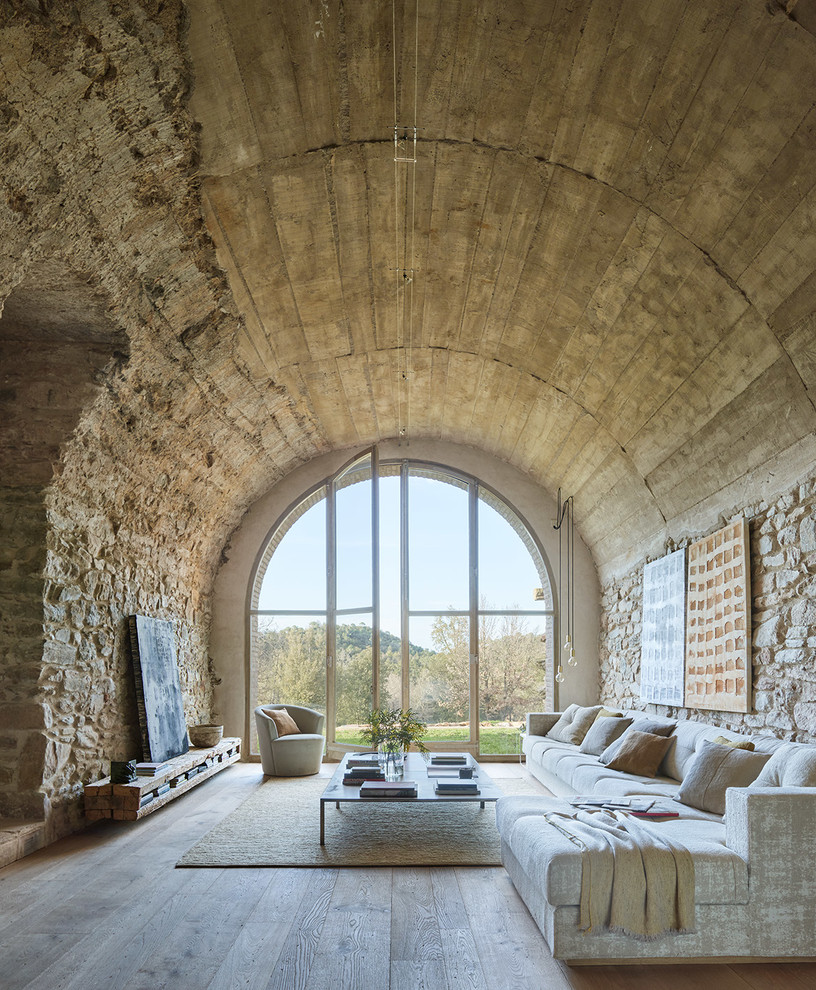 Mediterranean formal living room in Barcelona with beige walls, light hardwood flooring and grey floors.