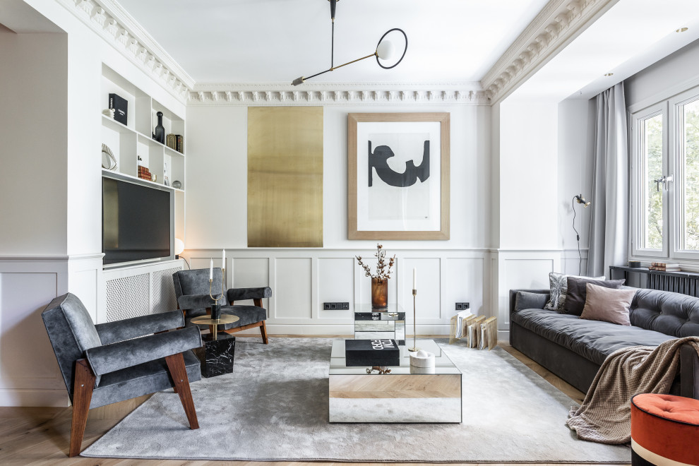 Photo of a scandi open plan living room in Madrid with white walls, medium hardwood flooring, a built-in media unit, brown floors and wainscoting.