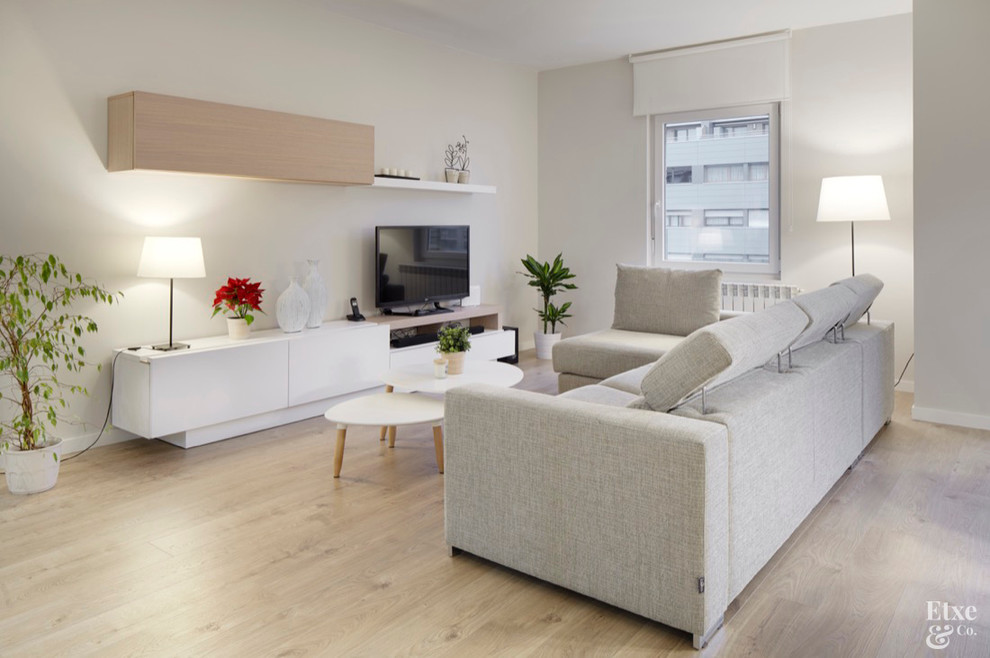 Идея дизайна: большая гостиная комната в скандинавском стиле с белыми стенами, паркетным полом среднего тона и отдельно стоящим телевизором