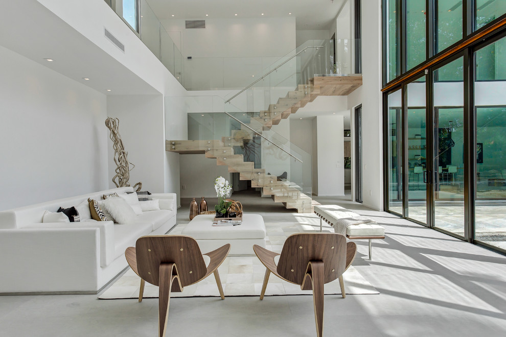 Photo of a contemporary formal open plan living room in Miami with white walls, no fireplace and grey floors.