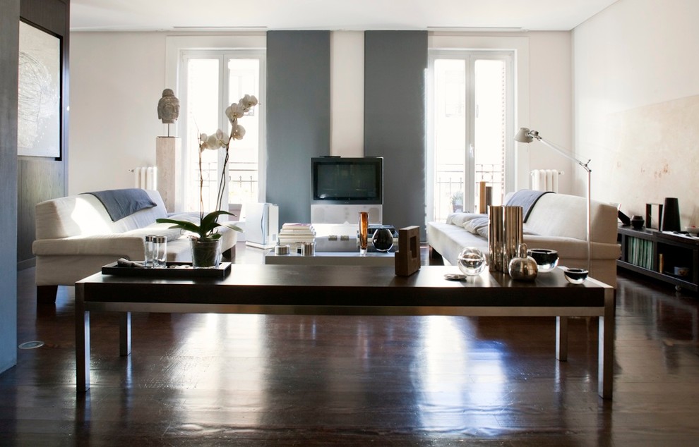 На фото: парадная, открытая гостиная комната среднего размера в современном стиле с белыми стенами, темным паркетным полом и отдельно стоящим телевизором без камина