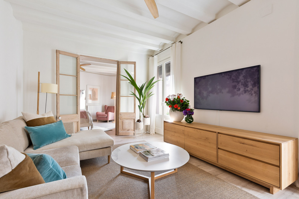 Immagine di un piccolo soggiorno mediterraneo aperto con pareti bianche, parquet chiaro e TV a parete