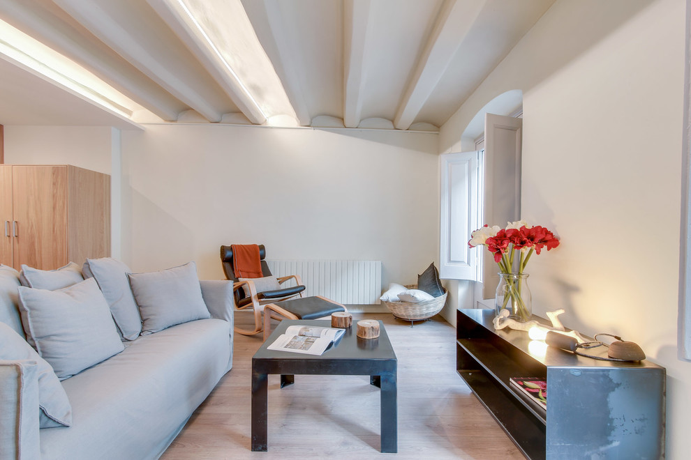 Imagen de salón para visitas abierto actual de tamaño medio sin chimenea y televisor con paredes blancas y suelo de madera clara