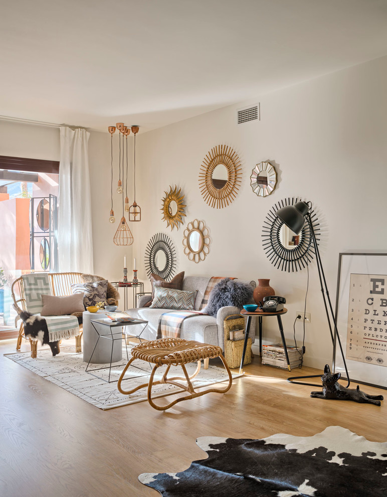 Diseño de salón para visitas abierto bohemio grande sin chimenea y televisor con paredes beige y suelo de madera clara