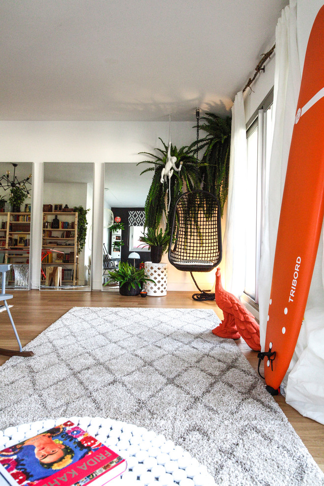 Modelo de salón para visitas abierto ecléctico de tamaño medio sin televisor con paredes negras y suelo de madera en tonos medios
