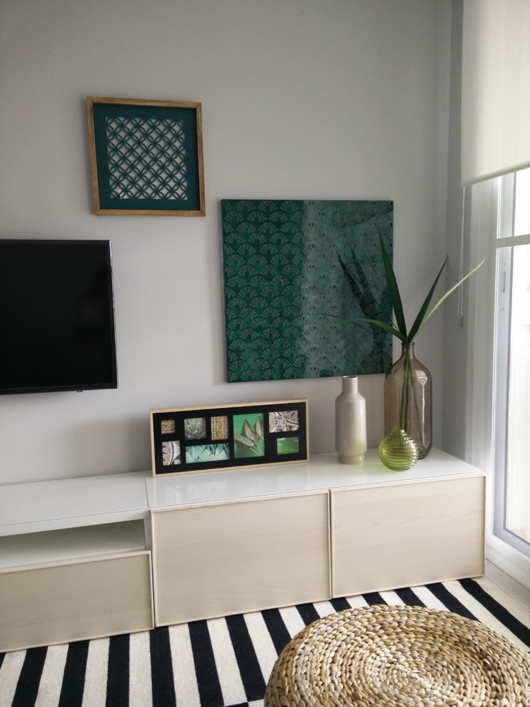 Foto de salón abierto contemporáneo de tamaño medio con paredes grises, suelo de madera clara, televisor colgado en la pared y suelo beige