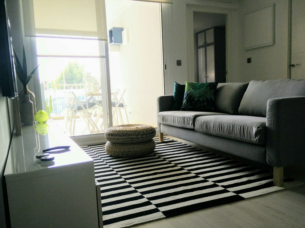 Foto di un soggiorno minimal di medie dimensioni e aperto con pareti grigie, parquet chiaro, TV a parete e pavimento beige
