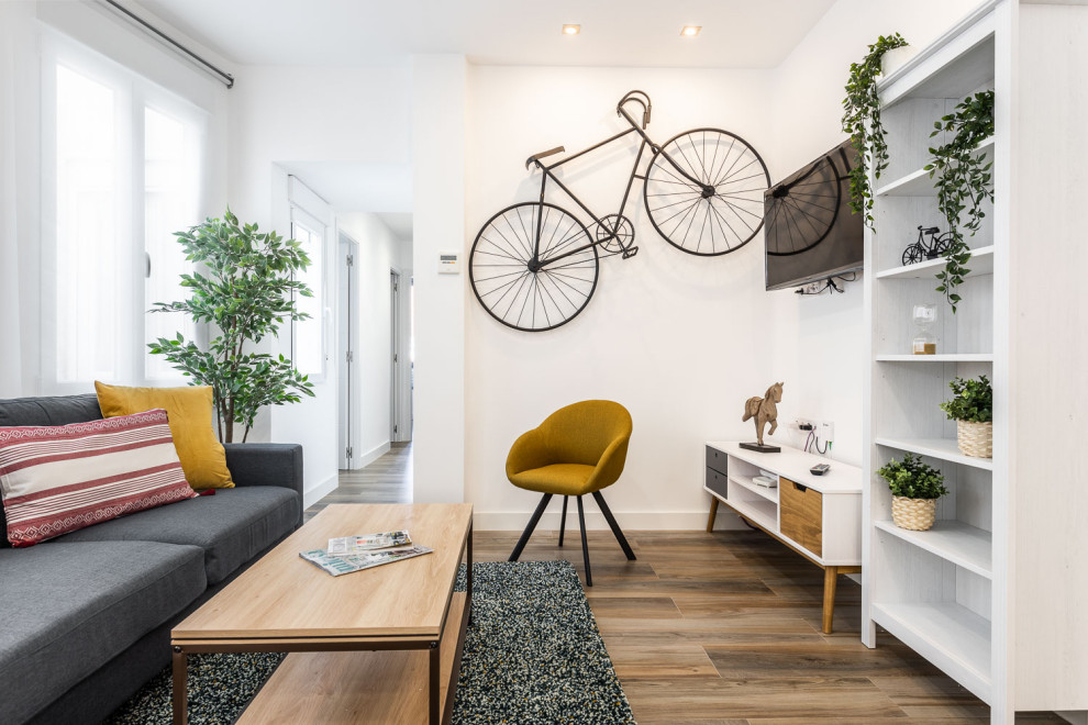 Foto di un soggiorno scandinavo con pareti bianche, TV a parete e pavimento marrone