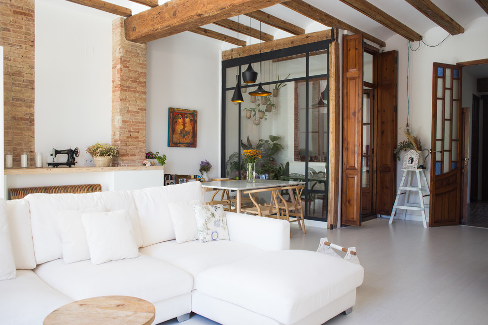 This is an example of a contemporary open plan living room in Valencia with white walls and beige floors.