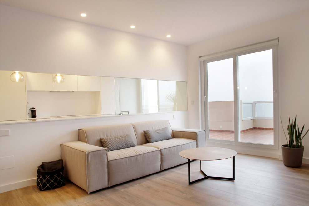 Imagen de salón abierto minimalista grande sin chimenea con paredes blancas, suelo de baldosas de cerámica, televisor independiente y suelo beige