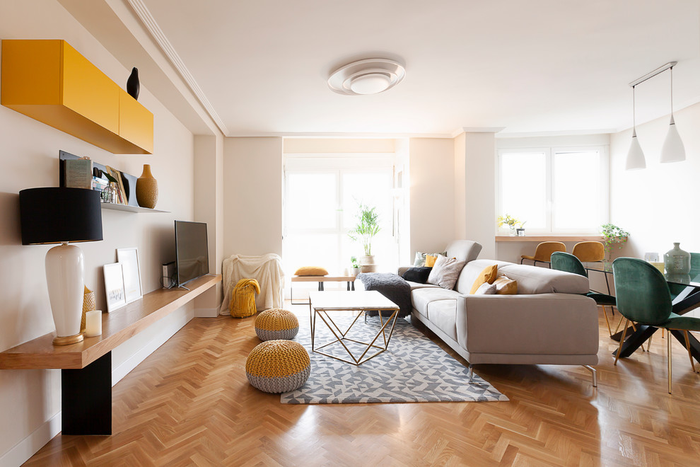 На фото: изолированная гостиная комната среднего размера в современном стиле с белыми стенами, отдельно стоящим телевизором, паркетным полом среднего тона и коричневым полом с