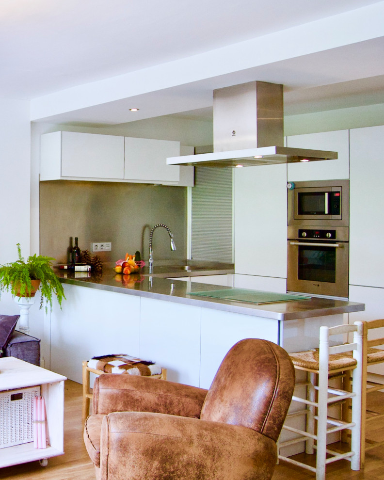 Mittelgroßes, Offenes Eklektisches Wohnzimmer mit Hausbar, weißer Wandfarbe, Laminat, TV-Wand und braunem Boden in Malaga