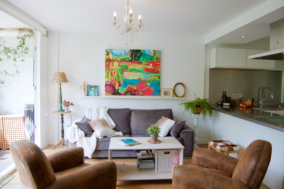 Imagen de salón con barra de bar abierto bohemio con paredes blancas, suelo laminado, televisor colgado en la pared y suelo marrón