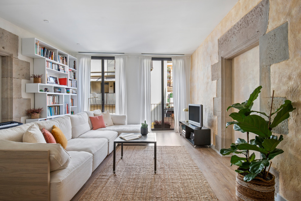 Diseño de salón contemporáneo con paredes beige, suelo de madera en tonos medios, televisor independiente y suelo marrón