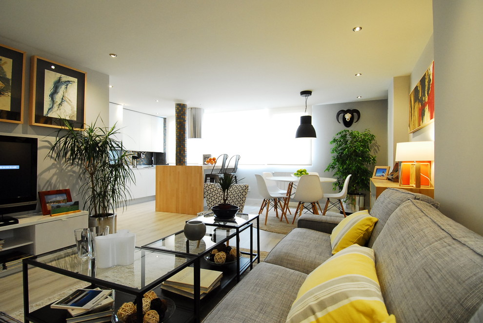 Immagine di un grande soggiorno minimal aperto con sala formale, pareti grigie, parquet chiaro, nessun camino e TV autoportante
