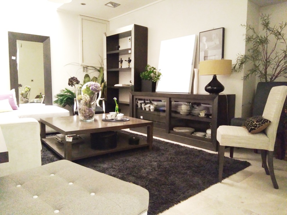 Modelo de salón para visitas actual con paredes beige, suelo de mármol y televisor independiente