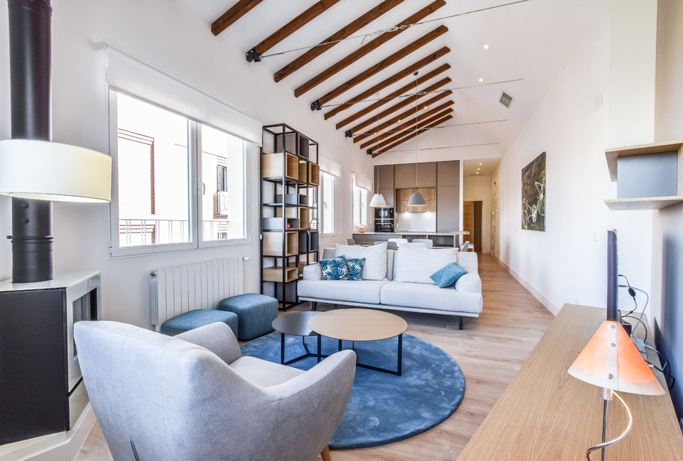 Diseño de salón abierto contemporáneo con paredes blancas, suelo de madera en tonos medios, chimenea de esquina, televisor independiente y suelo marrón