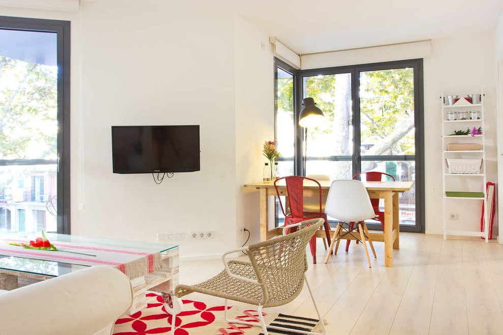 Bild på ett litet skandinaviskt loftrum, med vita väggar, mellanmörkt trägolv och en väggmonterad TV