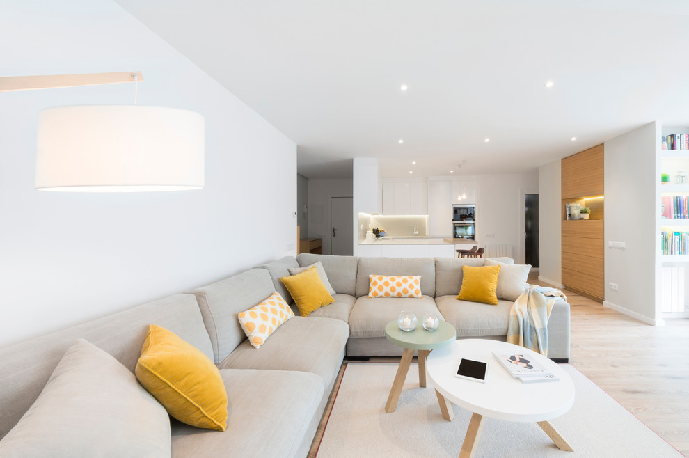Mittelgroßes, Offenes Skandinavisches Wohnzimmer ohne Kamin mit weißer Wandfarbe, hellem Holzboden und Multimediawand in Barcelona