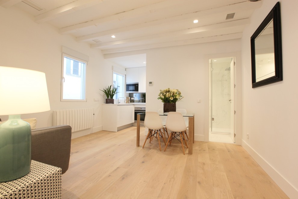 Imagen de salón tipo loft escandinavo pequeño con paredes blancas, suelo de madera clara, televisor colgado en la pared y suelo beige