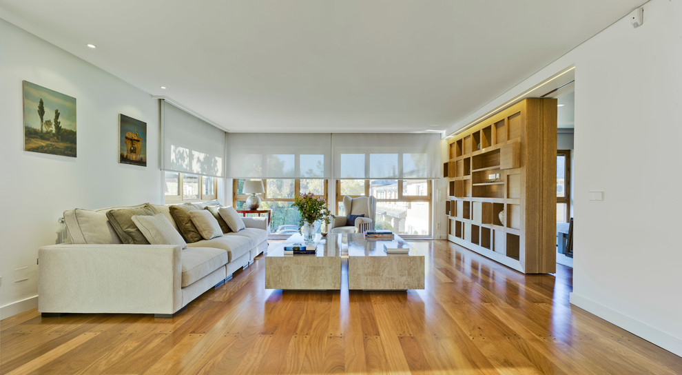 Immagine di un grande soggiorno contemporaneo aperto con sala formale, pareti bianche, pavimento in legno massello medio e nessun camino